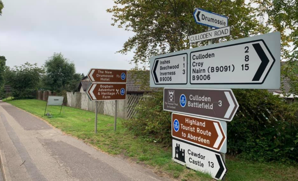 collection of road signs pointing to Culloden Battlefield, Cawdor Castle, and other locales